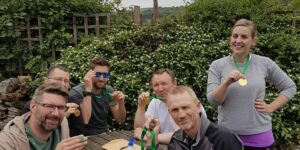 Team celebrating with medals after completing a Hunted team challenge in the Peak District.