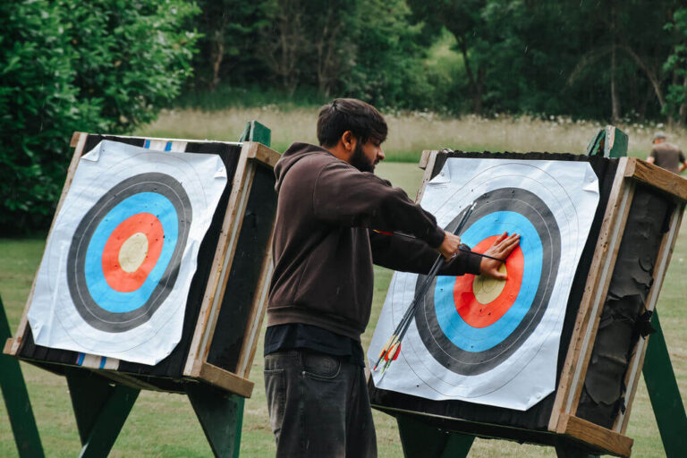 Man taking arrow out of target on a team building day