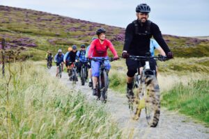 Several people ridding e bikes in the Peak District