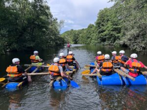Group kayaking on the River Derwent during a Peak District outdoor team experience.
