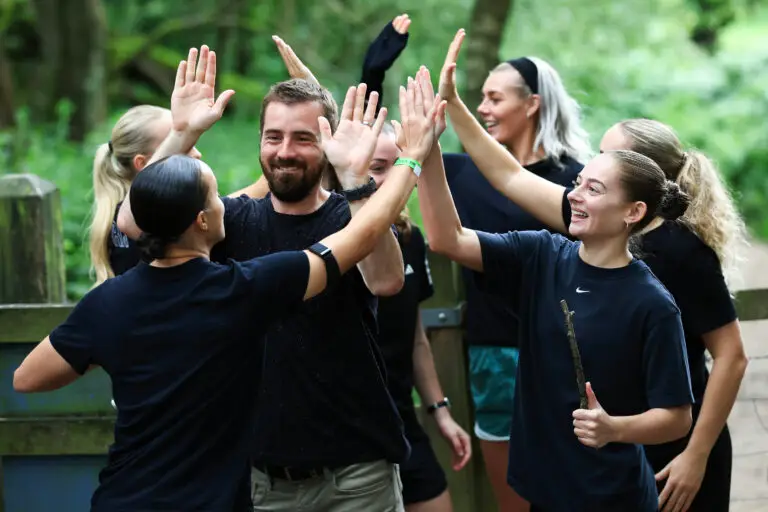 Team high-fiving during a Hunted-style team building activity in the Peak District