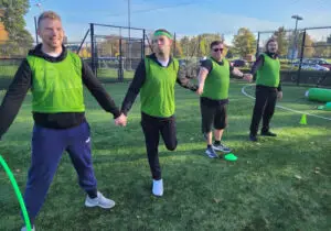 A group holding hands outside taking part in a team building activity
